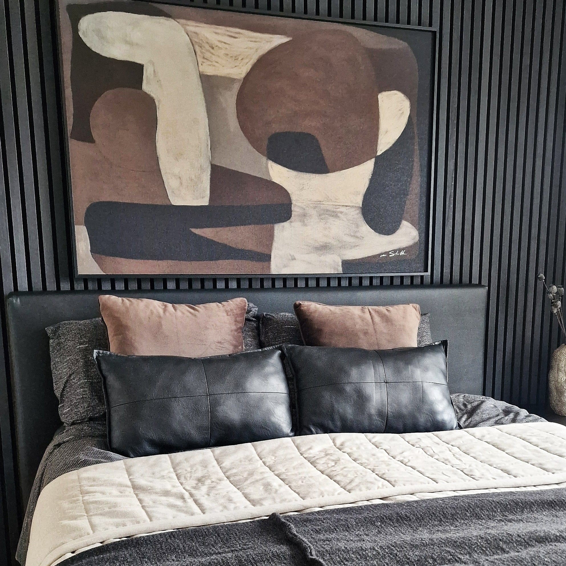 Luxe slaapkamer met zwarte wandpanelen en taupe kussens onder de Wandkraft Nexus wanddecoratie van Ilse van Stoltz voor een Quiet Luxury sfeer