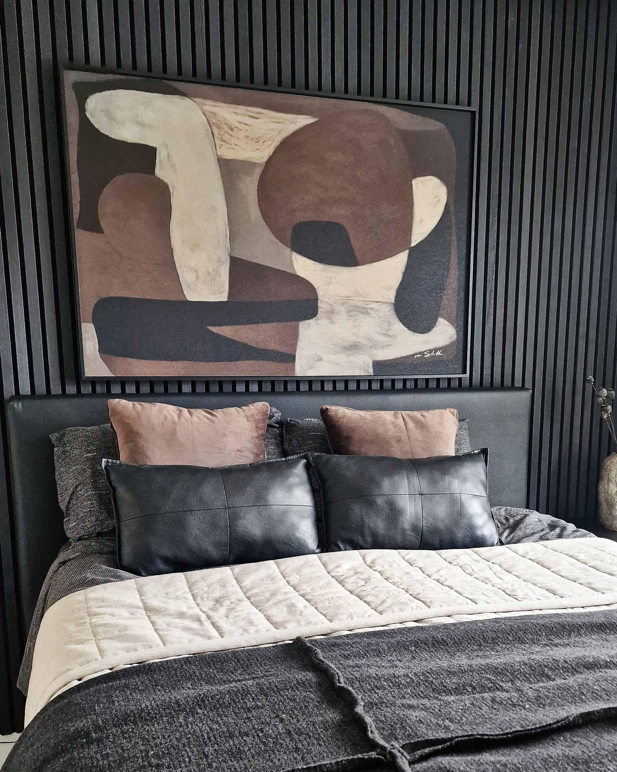 Luxe slaapkamer met zwarte wandpanelen en taupe kussens onder de Wandkraft Nexus wanddecoratie van Ilse van Stoltz voor een Quiet Luxury sfeer