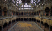 Décoration murale Wandkraft : art mural atmosphérique d'un hall abandonné et ouvragé aux arches, colonnes et balcons en tons terreux doux. Pour un intérieur élégant