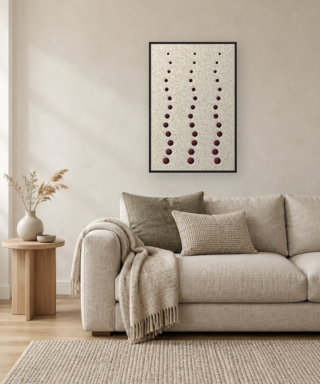 Pebble Rain viltpaneel met zwarte baklijst aan de wand boven een linnen bank in een warm modern interieur