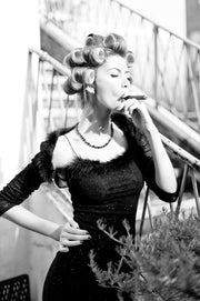Décoration murale Wandkraft : femme en robe noire et bigoudis fumant un cigare dans un escalier, allure puissante et vintage, dans le style de décoration murale de Wandkraft. Pour un intérieur élégant
