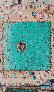 Wandkraft Wanddekoration: Luftaufnahme eines belebten Schwimmbads mit farbenfrohen Sonnenschirmen, Sonnenanbetern und Liegen, sommerliche, lebendige Wanddekoration. Für ein stilvolles Interieur