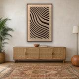Tidal Stripes viltpaneel met kastanjebruine baklijst boven een eiken dressoir met rotan deurtjes in een boho woonkamer