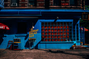 Wandkraft wanddecoratie: Blauwe winkelpui met gele accenten en oranje objecten, moderne stadswanddecoratie, Wandkraft Street Life 001. voor een stijlvol interieur